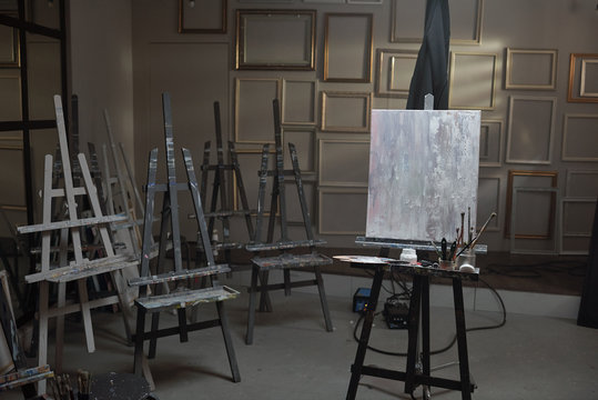 Interior of contemporary arts school or studio with unfinished picture on easel