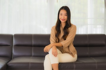 Portrait beautiful young asian woman happy smile relax on sofa in living room