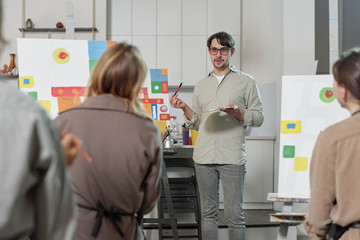 Obraz premium Confident teacher of painting explaining his students main rules of drawing