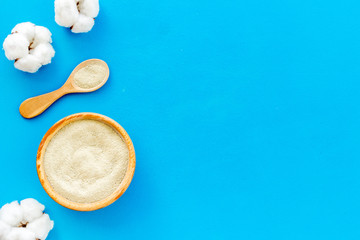 White cosmetic clay on blue background top-down copy space