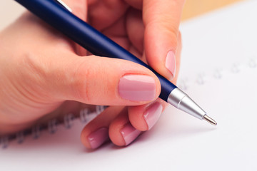 female hands write in a notebook . Office place . Close up view  - Image