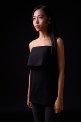 Portrait of young beautiful Asian woman looking away