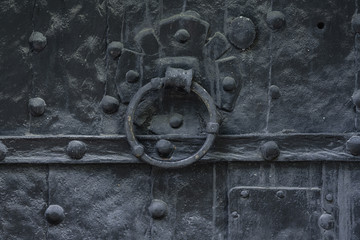 Old black church door with a knocker handle