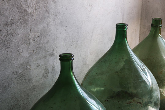 Primo piano di damigiane in vetro, contenitori per vino o aceto; oggetti vintage d’epoca