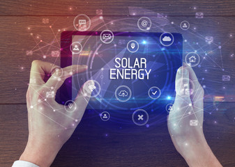 Close-up of a tablet with SOLAR ENERGY inscription, innovative technology concept