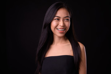 Naklejka premium Face of happy young beautiful Asian woman thinking