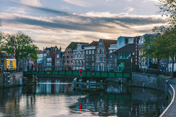 Obraz premium Cityscape of houses bordered by the Amsterdam canal, it is getting dark and the colors fade