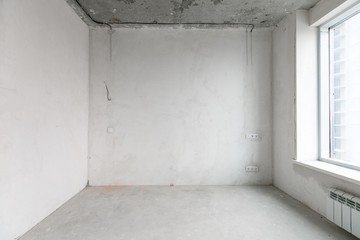 interior of a new apartment without finishing in gray tones with electrical wiring