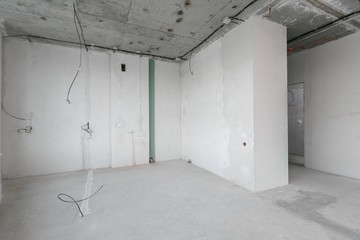 interior of a new apartment without finishing in gray tones with electrical wiring