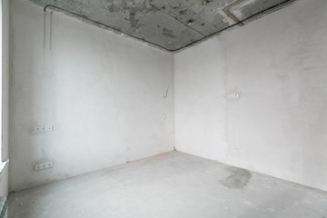 interior of a new apartment without finishing in gray tones with electrical wiring