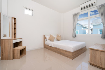 Wooden bed and dressing table in bedroom of house, villa, apartment and condo with a window
