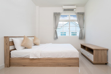 Wooden bed and TV console in bedroom of house, villa, apartment and condo