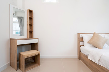 Wooden bed and dressing table in bedroom of house, villa, apartment and condo with a window