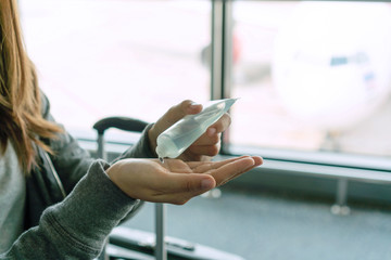 Woman applying sanitizer gel onto her hand for protection against infectious virus, bacteria and germs. Coronavirus/ Covid-19, health care concept.