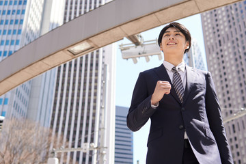 オフィス街で颯爽と歩く日本人男性ビジネスマン