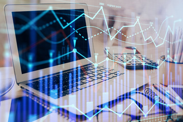 Stock market chart hologram drawn on personal computer background. Double exposure. Concept of investment.