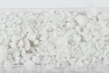 Many crystals of white salt on the heap. Texture of pieces of salt.