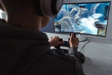 The gamer sitting at the table and playing video games