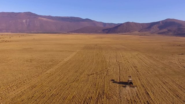 Aerial view of tractor on a field in Lika, Croatia.