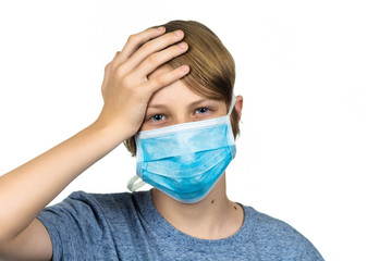 Young teenage boy with headache wearing protective mask.