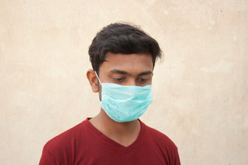 Young Boy wearing protective face mask standing in front of a Grey background