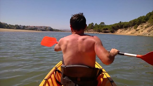 Man kayaking on the River Pas mouth in Liencres dunes nature reserve in the Cantabrian sea 