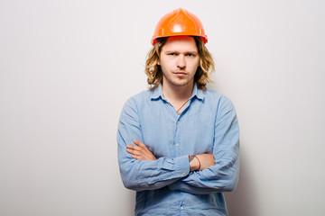 Handsome young man with protective helmet on his head and arms crossed