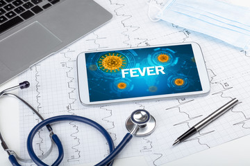 Close-up view of a tablet pc with FEVER inscription, microbiology concept