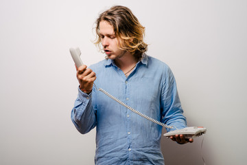Close up image of a man screaming on the telephone during the conversation.