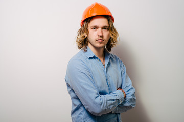 Handsome young man with protective helmet on his head and arms crossed