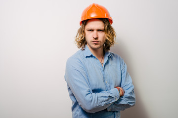 Handsome young man with protective helmet on his head and arms crossed