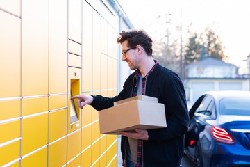 Ein Mann an einer Packstation, Pakete abholen und verschicken