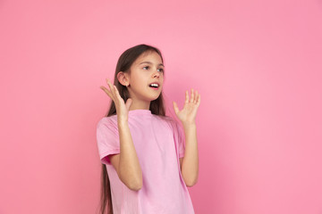Obraz na płótnie Canvas Astonished, shocked. Caucasian little girl portrait isolated on pink studio background. Cute brunette model in shirt. Concept of human emotions, facial expression, sales, ad, childhood. Copyspace.