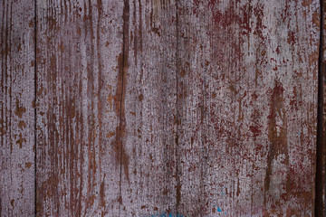 Fototapeta na wymiar Old red wooden texured door surface closeup. Relief on surface. Stock photo of old wooden door pattern of aged boards with scratches. Red and gray colors on photo.