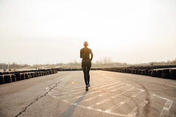 morning run of a young girl on the street in black leggings and sneakers