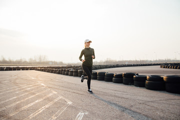 morning run of a young girl on the street in black leggings and sneakers