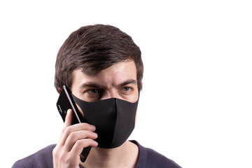 Young man in black antibacterial mask is talking on mobile phone. Epidemic Coronavirus 2019-nCoV.