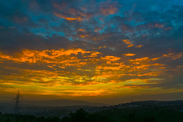 golden hour sunset outskirt the city with transmission line in the background