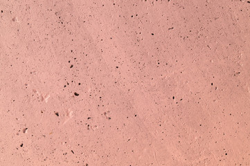 The pink concrete wall. The wall is textured.