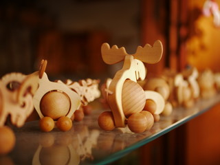 Wooden toys on a glass shelf representing different animals like moose.