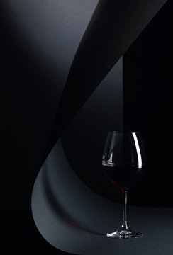 Glass of red wine on a black background.
