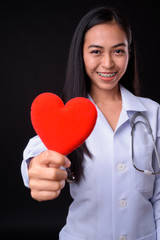 Happy young Asian woman doctor as cardiologist giving heart