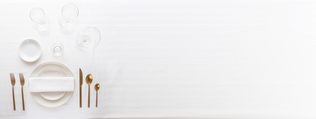 Elegant  table setting with white plates, silver cutlery and glasses for festive dinner. Large image for banner