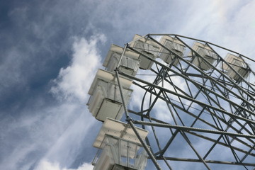 Ferris wheel in amusement park against cloudy sky