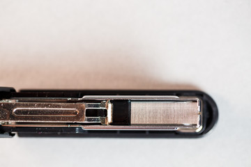 black stapler for fastening papers on a gray background
