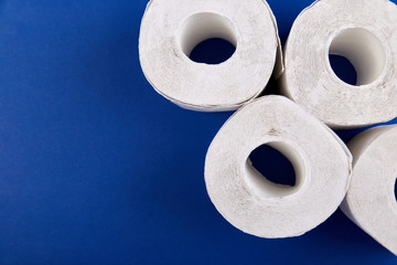 Coronavirus pandemic panic shopping concept. Flat lay of Toilet paper rolls on the bright blue...