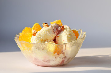 Vanilla ice-cream with fruits and chopped nuts,delicious snack 