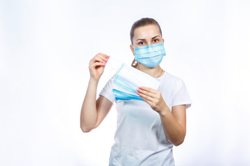 A girl in a protective medical mask holds in her hands means to protect the respiratory tract from the virus.