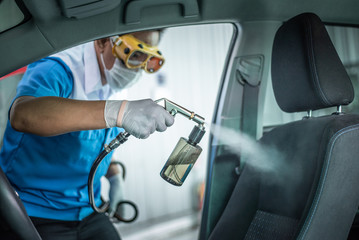 Clean surfaces in car with a disinfectant spray. Help kill coronavirus in  car after going out. - obrazy, fototapety, plakaty