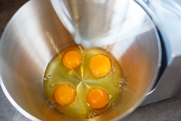 Beating eggs with sugar in a kitchen machine. Cream nozzle